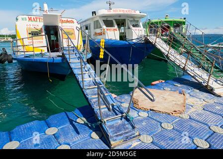 Traditionelle Fährschiffe dockten an einer schwimmenden Kunststoffplattform im Hafen Tabon in Caticlan, Provinz Aklan, dem Tor zur Insel Boracay, Philippinen Stockfoto