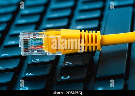 Konzept der Netzwerkzugangstechnologie. Internet-lan-Kabel auf einer Desktop-Tastatur.Online verboten Ressource konzeptionell. Stockfoto