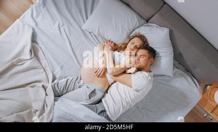 Glücklich Junges Paar schlafen zusammen im Bett, Sweet Loving Young People Halten einander während des Schlafens. Schöne Frau ist schwanger, liebevoll Stockfoto