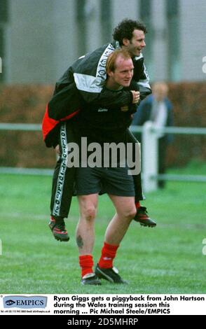 Ryan Giggs bekommt einen Huckepack von John Hartson während der Schulung in Wales heute Morgen Stockfoto