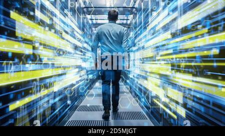 Aufnahme eines jungen IT-Spezialisten, der durch den Korridor in einem funktionierenden Rechenzentrum mit Rack-Servern und Supercomputern geht. Konzeptionelle Visualisierung von Stockfoto