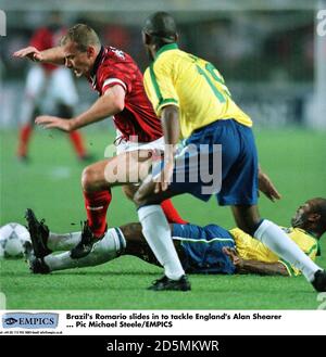 Brasiliens Romario rutscht ein, um sich gegen Englands Alan Shearer zu stellen Stockfoto