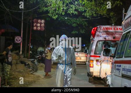 Mandalay, Myanmar. September 2020. Ein Mitarbeiter des Gesundheitswesens, der einen persönlichen Schutzanzug (PSA) trägt, wird gesehen, wie er draußen neben den Krankenwagen auf die vermuteten Covid-19-Patienten wartet.EIN Mann aus dem Viertel Amarapura Township testete positiv auf Coronavirus (COVID19), obwohl er keine Covid-19-Zeichen gezeigt hatte. Es gibt mehr als 25 Menschen, die in engem Kontakt mit ihm gewesen sind, also sind medizinische Arbeiter mit Krankenwagen in das Viertel geeilt, um zu sehen, dass die Menschen, die in engem Kontakt mit dem Covid-19 Opfer waren, zur näheren Untersuchung in die Quarantänestelle gebracht werden. (Kredit I Stockfoto