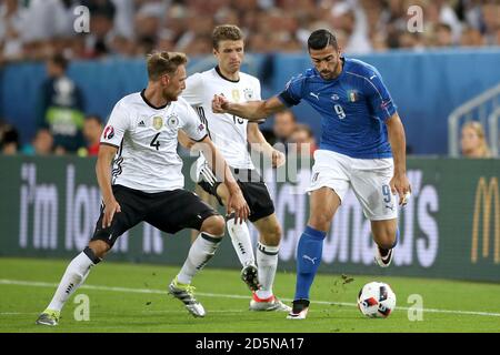 Der Italiener Graziano Pelle (rechts) kämpft mit dem Deutschen um den Ball Benedikt Howedes (links) und Thomas Muller Stockfoto