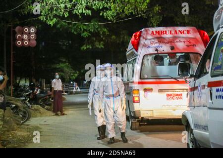 Mandalay, Myanmar. September 2020. Gesundheitshelfer, die persönliche Schutzanzüge (PSA) tragen, werden gesehen, wie sie draußen neben den Krankenwagen auf die vermuteten Covid-19-Patienten warten.EIN Mann aus dem Viertel der Gemeinde Amarapura testete positiv auf Coronavirus (COVID19), obwohl er keine Covid-19-Zeichen gezeigt hatte. Es gibt mehr als 25 Menschen, die in engem Kontakt mit ihm gewesen sind, also sind medizinische Arbeiter mit Krankenwagen in das Viertel geeilt, um zu sehen, dass die Menschen, die in engem Kontakt mit dem Covid-19 Opfer waren, zur näheren Untersuchung in die Quarantänestelle gebracht werden. (Bild: Stockfoto