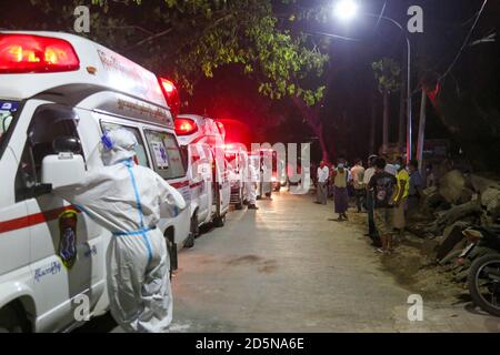 Mandalay, Myanmar. September 2020. Gesundheitshelfer, die persönliche Schutzanzüge (PSA) tragen, werden gesehen, wie sie draußen neben den Krankenwagen auf die vermuteten Covid-19-Patienten warten.EIN Mann aus dem Viertel der Gemeinde Amarapura testete positiv auf Coronavirus (COVID19), obwohl er keine Covid-19-Zeichen gezeigt hatte. Es gibt mehr als 25 Menschen, die in engem Kontakt mit ihm gewesen sind, also sind medizinische Arbeiter mit Krankenwagen in das Viertel geeilt, um zu sehen, dass die Menschen, die in engem Kontakt mit dem Covid-19 Opfer waren, zur näheren Untersuchung in die Quarantänestelle gebracht werden. (Bild: Stockfoto