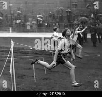 M. Kirk in einem feinen Finish in einer Hitze der 100 Yards Ladies Open Handicap, die sie gewann. Hunderte von Sportlerinnen nahmen am Genfer Sporttreffen an der Stamford Bridge, Fulham, London, Teil. Stockfoto