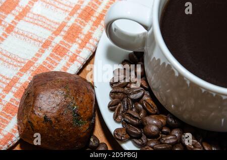 Weiße Tasse mit Kaffeebohnen auf dem Tisch Stockfoto