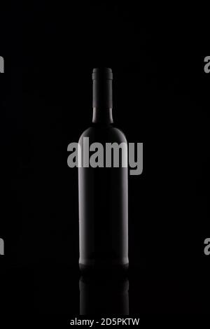 Weinflasche Silhouette isoliert auf dunklem Hintergrund. Nachbau der Flasche vor dunklem Hintergrund. Stockfoto