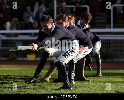 Die verletzten Jockeys finanzieren das Tauziehen in die Sieger Gehege während des Landtages Tag der offenen Tür in Cheltenham Rennbahn Stockfoto