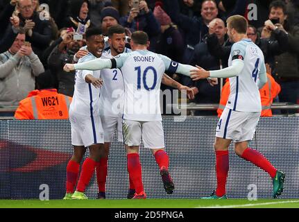 Der Engländer Daniel Sturridge (links) schiebt sich mit den Teamkollegen Kyle Walker, Wayne Rooney und Eric Dier nach dem ersten Tor seiner Mannschaft Stockfoto