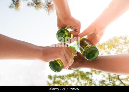 Eine Gruppe von Freunden, die mit Bier im Garten toasten Stockfoto