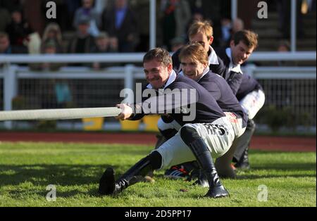 Die verletzten Jockeys finanzieren das Tauziehen in die Sieger Gehege während des Landtages Tag der offenen Tür in Cheltenham Rennbahn Stockfoto