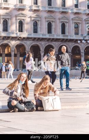 Junge Leute, die während des covid Ausbruchs im Zentrum von Mailand mit und ohne Gesichtsmasken spazieren gehen. Milan, Italien - 27.09.2020 Stockfoto