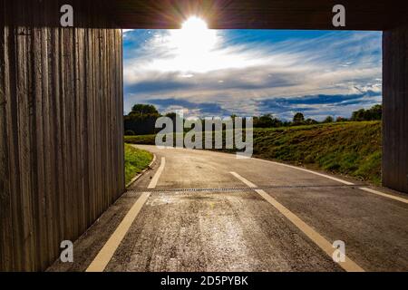 Sonne scheint durch das Ende eines quadratischen Tunnels Stockfoto