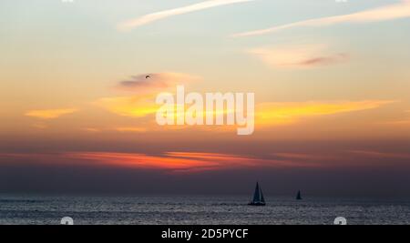 Boot segelt entlang gegen einen lebendigen bunten Sonnenuntergang. Golf von Finnland. Stockfoto