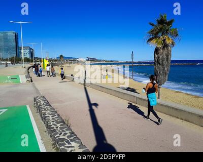 Leute, die in einer Promenade in der Nähe des Strandes spazieren gehen. Platja de la Nova Mar Bella. Passeig Marítim del Bogatell, Barcelona, Katalonien, Spanien. Stockfoto