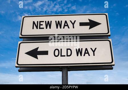 Neues Wegzeichen gegen altes Wegzeichen. Weiße zwei Straßenschilder mit Pfeil auf Metallmast mit Wort. Richtungsstraße. Kreuzung Straßenschild, Zwei Pfeil. Stockfoto