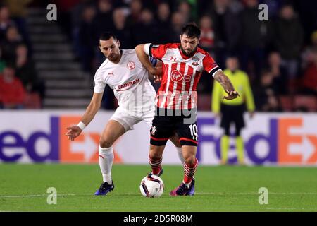 Southampton's Charlie Austin (rechts) und Hapoel Be'er Sheva's Shir Tzedek Kampf um den Ball Stockfoto