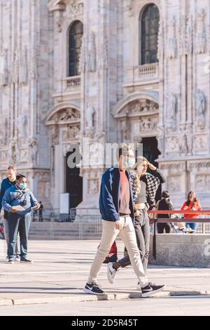 Menschen tragen Schutzmasken verhindern Coronavirus, covid 19 während des Virenausbruchs. Junge Leute zu Fuß im Zentrum von Mailand. Milan, Italien - 27.09.2020 Stockfoto