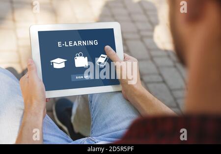 Schwarzer Mann mit Tablet mit Bildungs-Website Stockfoto