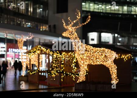 Verschwommene Lichter der weihnachtsinstallation - defokussieren Lichter der Hirsch Nacht Stadt Hintergrund. Installation von Weihnachtshirschen. Milan, Italien - 25.12.2019 Stockfoto