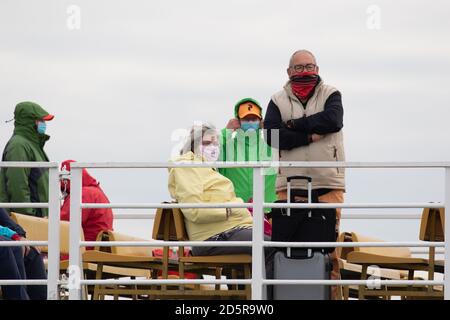 Touristen tragen Gesichtsmasken während der Fahrt auf der Fähre von den friesischen Inseln während der covid-19 Pandemie. Niedersachsen. Deutschland. Oktober 2020 Stockfoto