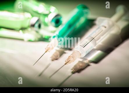 Zwei Spritzen und Fläschchen mit Impfstoff im Rampenlicht Stockfoto