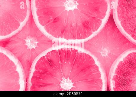 Frische rosa Fruchtstruktur in Scheiben geschnitten. Makro, Draufsicht, Kopierbereich. Saftige Orangen Hintergrund. Stockfoto
