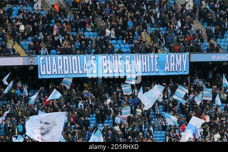 Manchester City Fans mit einem Banner mit Guardiolas blauem und Weiße Armee in den Tribünen Stockfoto