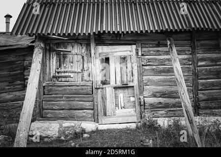 Schwarz-weiße Fassade aus alter und verfallenen Holz- und Metallhütte in den Bergen des Asiago-Plateaus. Enego, Vicenza, Italien Stockfoto