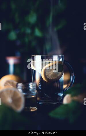 Heißer Tee mit Zitrone und Minze in einer Glasschale Stockfoto