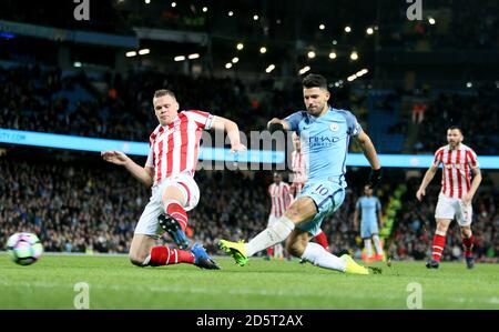 Sergio Aguero von Manchester City schießt als Ryan Shawcross von Stoke City Herausforderungen Stockfoto