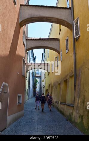 Passau, Deutschland - 17. Juli 2018: Nicht identifizierte Menschen zwischen Gebäuden in einer engen Gasse mit Brücken in Bayern nahe der Grenze mit der Stockfoto