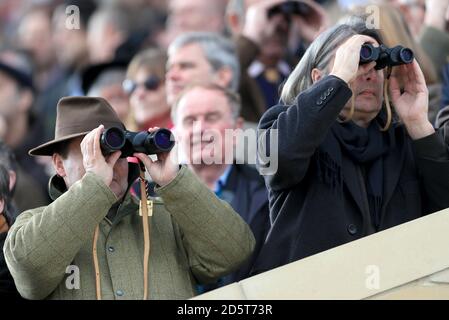 Racegoers beobachten das Geschehen durch ihr Fernglas am ersten Tag Des Cheltenham Festivals 2017 Stockfoto