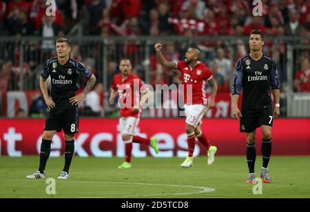 Bayern München's Arturo Vidal (zweite rechts) Feiert das erste Tor seiner Spieleseite während des Spiels Echte Madrids Toni Kroos (links) und Cristiano Ronaldo (rechts) sehen aus Dejeziert Stockfoto