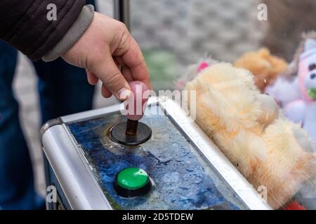 01 05 2020 Gomel, Republik Weißrussland. Spielautomat mit weichen Spielzeugen, Joystick und Hand eines Mannes aus der Nähe Stockfoto