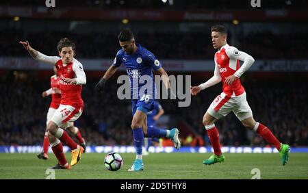 Riyad Mahrez von Leicester City (Mitte) läuft in den Strafraum, vorbei an Gabriel Paulista von Arsenal (rechts) und Hector Bellerin (links) Stockfoto