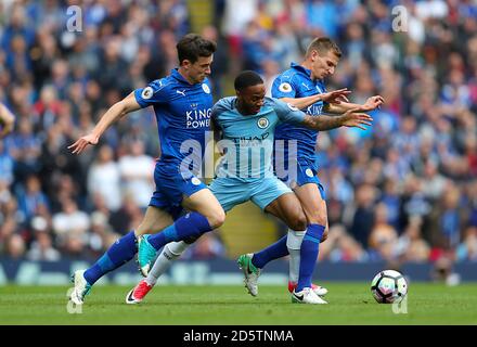 Mit Raheem Sterling (Mitte) von Manchester City kämpft man um den Ball Marc Albrighton (rechts) und Ben Chilwell von Leicester City Stockfoto