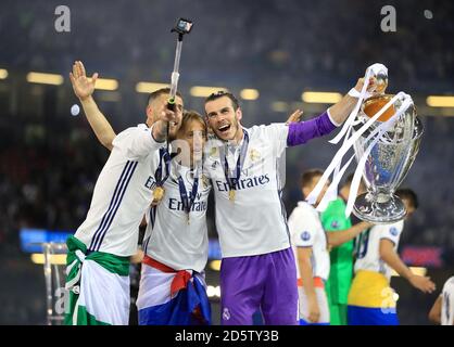 Sergio Ramos von Real Madrid (links), Luka Modric (Mitte) und Gareth Bale feiern mit der Trophäe nach dem Champions-League-Finale 2017 im Nationalstadion von Cardiff Stockfoto