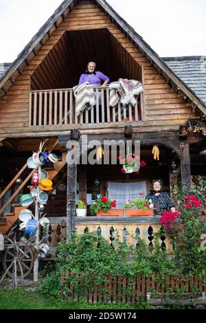 BREB, RUMÄNIEN - 11. OKTOBER 2020: Zwei ältere Frauen stehen auf der Veranda eines traditionellen Holzhauses in Maramures. Stockfoto