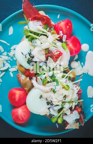 Passhot Sandwich in flat lay.Bruschetta Snack mit gekochten Hühnereiern, getrocknet Tomaten, Mikrogemüse, frisches Kirschtomatengemüse auf dem Teller serviert Stockfoto