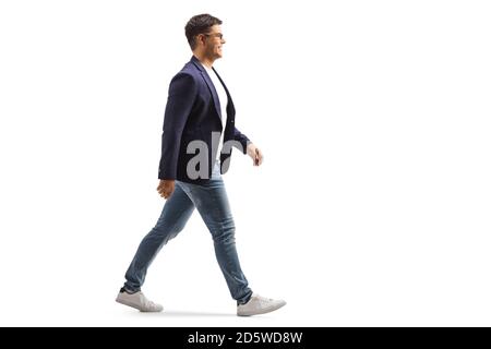 In voller Länge Profilaufnahme eines lächelnden jungen Mannes in Jeans und Anzug zu Fuß isoliert auf weißem Hintergrund Stockfoto