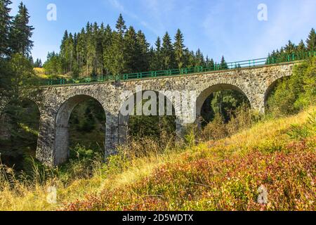 Blick auf Steinbahn Viadukt in einem kleinen Dorf von Pernink, Tschechische republik. Alte tschechische Eisenbahnlinie. Alte Bogenbrücke Stockfoto