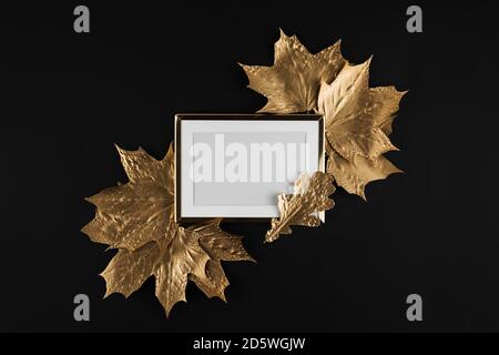 Herbstkomposition. Goldener Rahmen mit herbstlichen goldenen Ahornblättern auf schwarzem Hintergrund. Flach liegend, Draufsicht, Kopierbereich Stockfoto