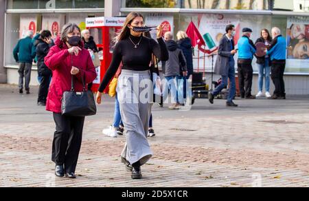 Dundee, Tayside, Schottland, Großbritannien. Oktober 2020. UK Wetter: Ein heller Tag mit gelegentlichem Sonnenschein und leichtem Wind über den Nordosten Schottlands, Höchsttemperaturen 13 Grad Zwei Frauen, die während der Covid-19 Lockdown im Stadtzentrum von Dundee zusammen mit Gesichtsmasken und Haaren im leichten Wind herumlaufen. Kredit: Dundee Photographics/Alamy Live Nachrichten Stockfoto