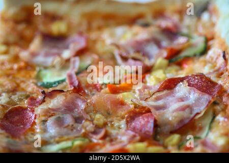 Nahaufnahme der hausgemachten Pizza mit Speck, Pilzen, Salami, Schinken, Pfeffer, Zwiebel und Gurke Stockfoto