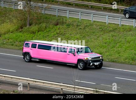 Eine rosa gestreckte Hummer-Limousine auf der Autobahn M40, Warwickshire, Großbritannien Stockfoto