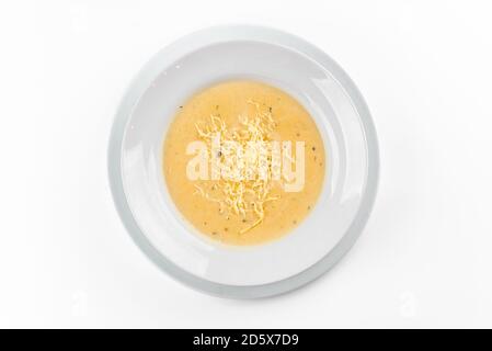 Käsesuppe auf weißem Teller auf weißem Hintergrund Stockfoto