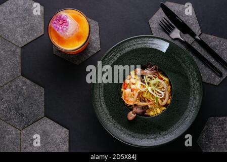 Spanische Paella auf schwarzem Hintergrund Stockfoto